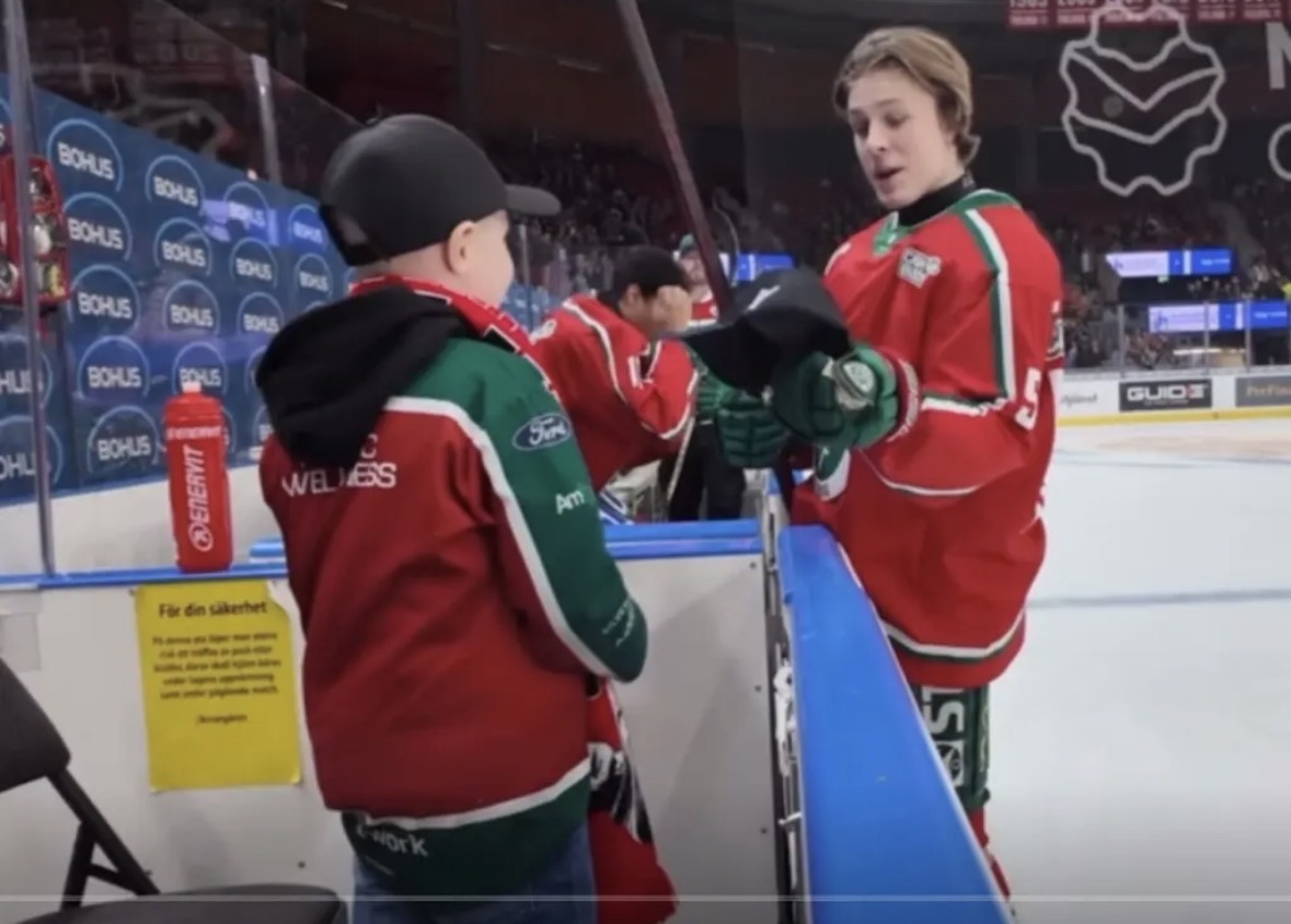 Ture får handskar av en spelare vid sargen